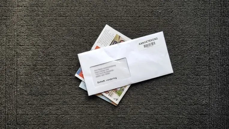 Aangetekende brief met een vordering op de schoonloopmat bij de ingang van een zaak