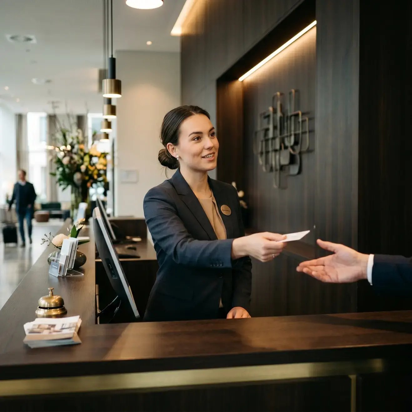 Receptioniste overhandigt een keycard aan een gast bij de incheckbalie van een hotel